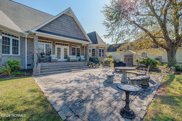 exterior space with a yard, a storage shed, french doors, and a patio area