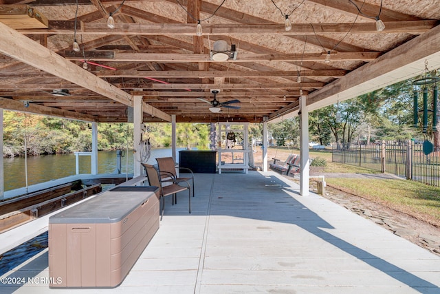 view of patio / terrace featuring a water view, ceiling fan, and a boat dock