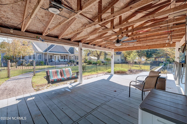 wooden deck with a lawn and ceiling fan