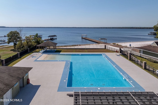 view of pool with a water view, a patio, and a dock