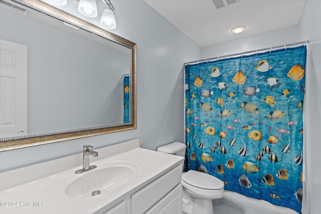 bathroom with vanity, a textured ceiling, toilet, and walk in shower