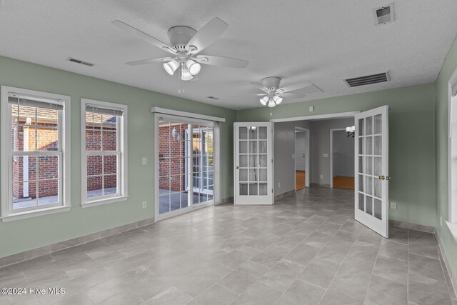 unfurnished room with french doors, a textured ceiling, and ceiling fan