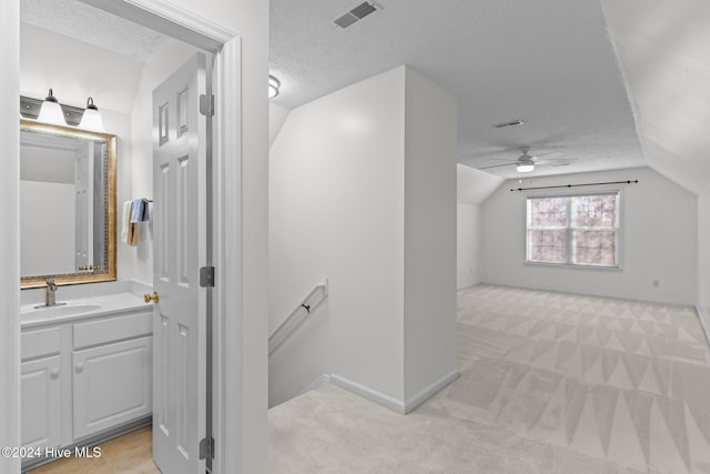 7319 Thurgood Rd, Wilmington, NC 28411 - additional living space featuring a sink, light colored carpet, vaulted ceiling, a ceiling fan, and a textured ceiling