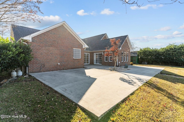 rear view of property with a lawn and a patio area