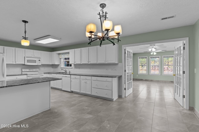 kitchen featuring decorative light fixtures, white cabinetry, white appliances, and sink