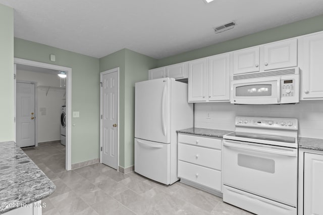 kitchen featuring white cabinets, washer / dryer, white appliances, and light stone counters