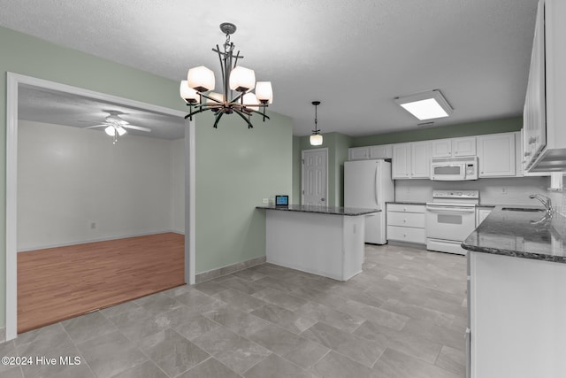 kitchen featuring white appliances, sink, kitchen peninsula, decorative light fixtures, and white cabinetry