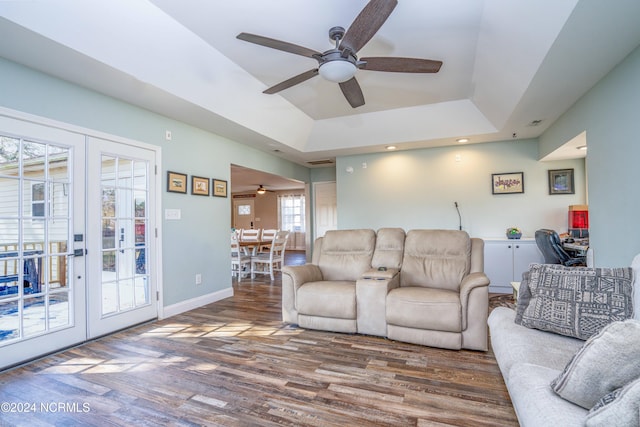 living room featuring french doors, dark hardwood / wood-style floors, a tray ceiling, and ceiling fan