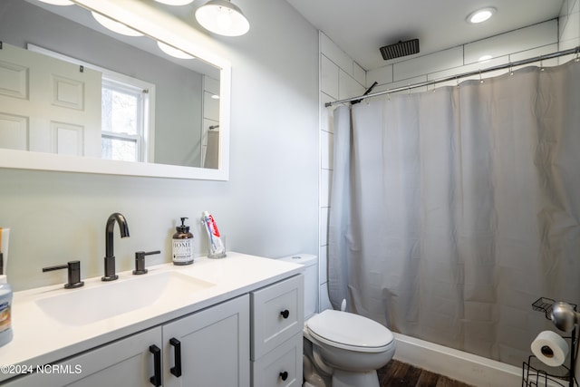 bathroom featuring vanity, curtained shower, wood-type flooring, and toilet