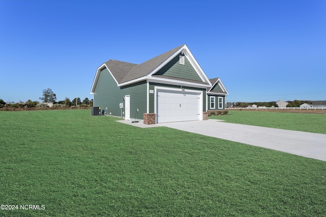 craftsman-style house with central air condition unit, a front lawn, and a garage