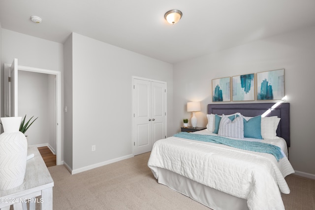 bedroom featuring light carpet and a closet