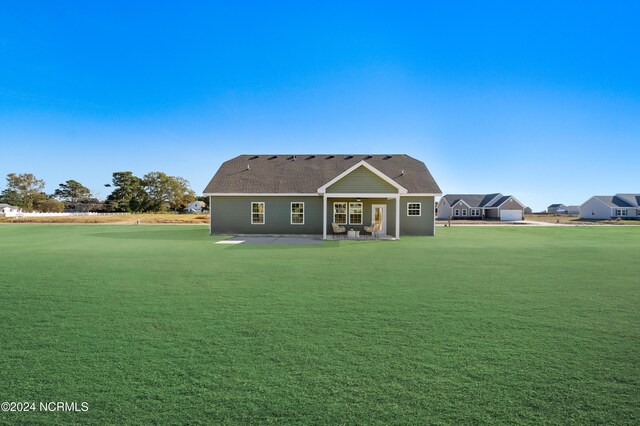 back of property with a yard and a patio