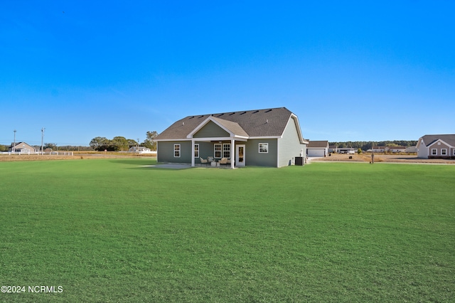 rear view of house with a patio and a lawn