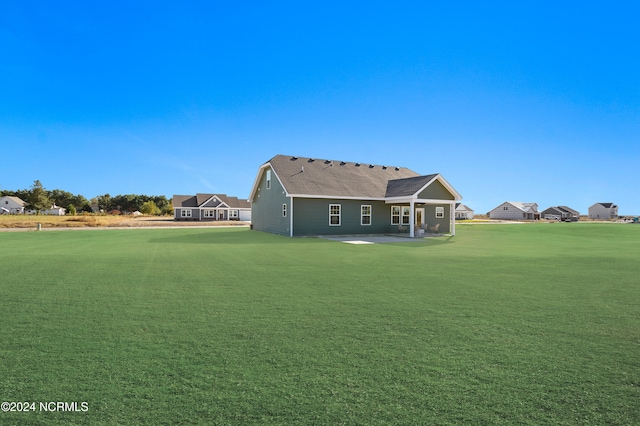 back of house with a patio and a lawn