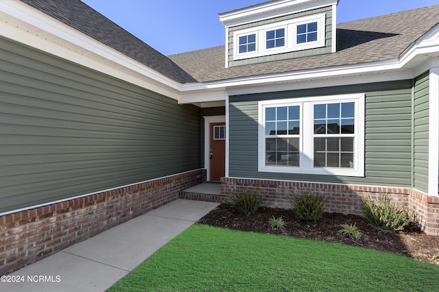 entrance to property featuring a lawn