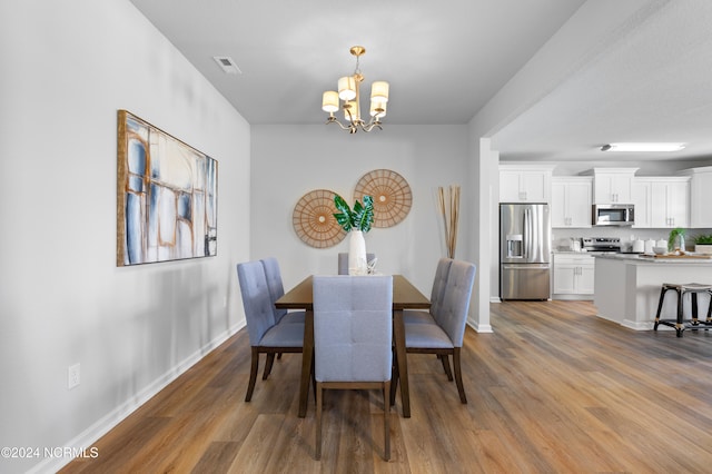 dining area with an inviting chandelier and dark hardwood / wood-style floors