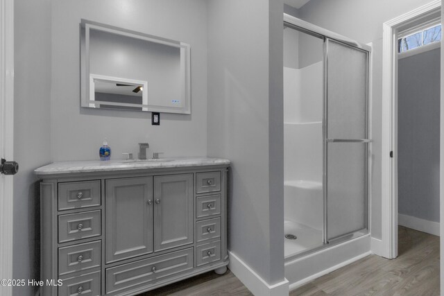 bathroom featuring vanity, wood-type flooring, and walk in shower