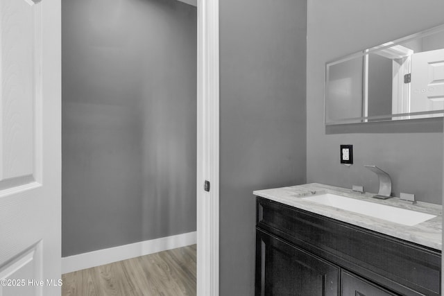 bathroom with baseboards, wood finished floors, and vanity