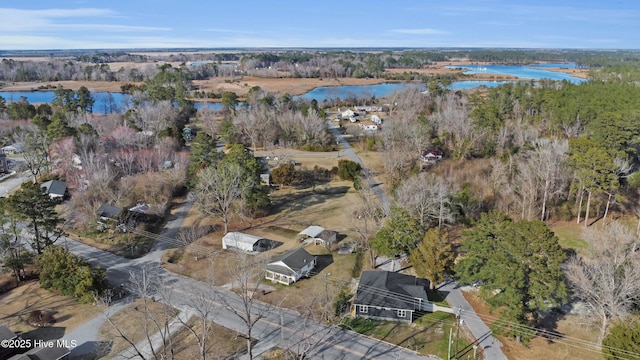 birds eye view of property featuring a water view and a wooded view