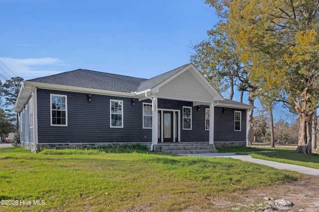 view of front of home featuring a shingled roof, a front yard, and a porch