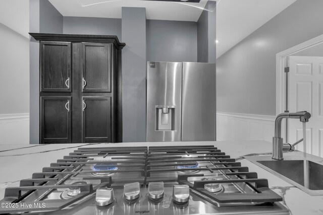 kitchen with light stone counters, double oven, wood-type flooring, pendant lighting, and a kitchen island