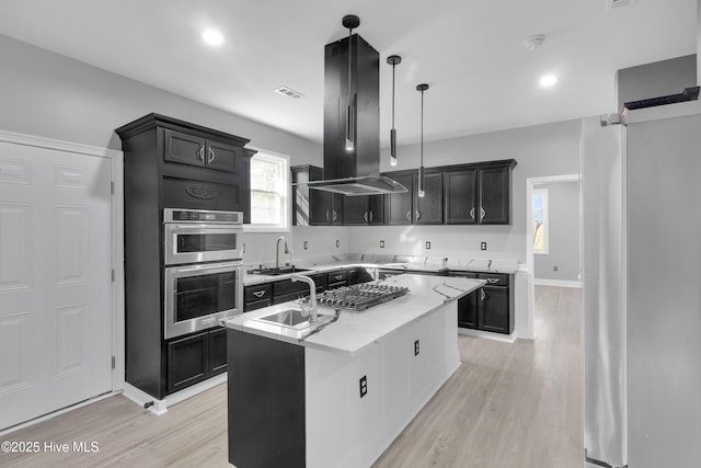 kitchen with double oven, a sink, visible vents, a center island, and island exhaust hood