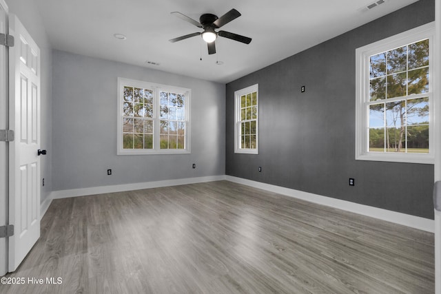 unfurnished bedroom with ceiling fan, wood finished floors, visible vents, and baseboards