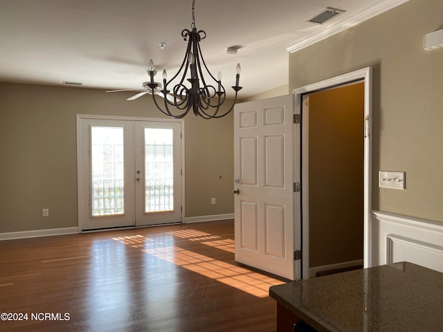 unfurnished dining area with french doors, dark wood-type flooring, crown molding, vaulted ceiling, and ceiling fan with notable chandelier