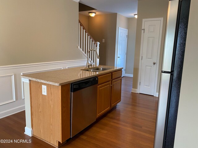 kitchen featuring stainless steel appliances, dark hardwood / wood-style floors, a center island with sink, and sink