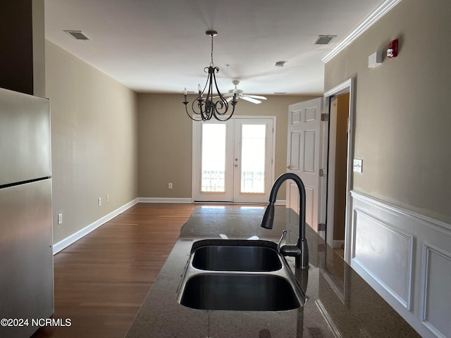 kitchen featuring french doors, sink, hardwood / wood-style flooring, stainless steel fridge, and dark stone countertops