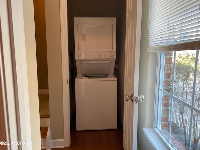 washroom featuring hardwood / wood-style flooring and stacked washer / drying machine