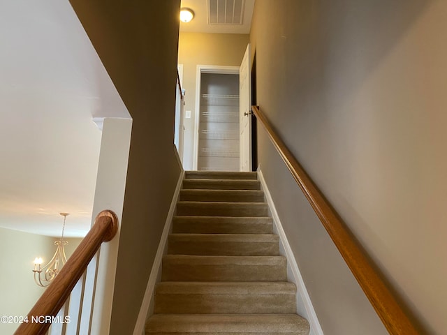 stairs featuring a chandelier