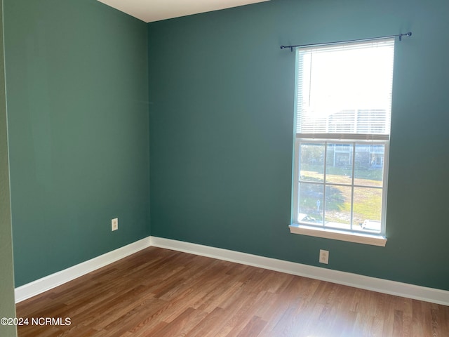 spare room featuring a wealth of natural light and hardwood / wood-style floors