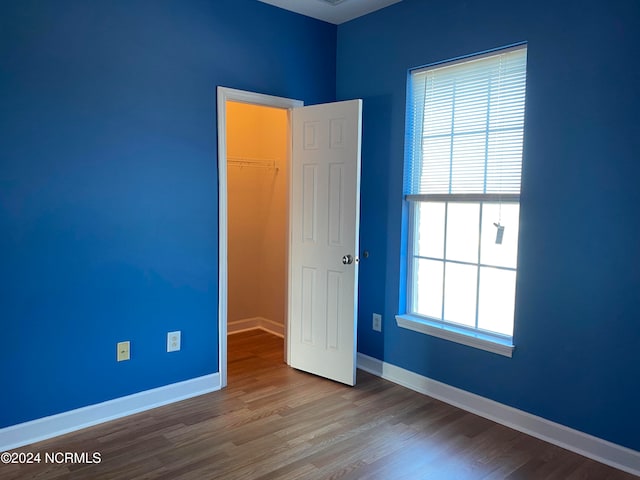 unfurnished room featuring plenty of natural light and hardwood / wood-style floors