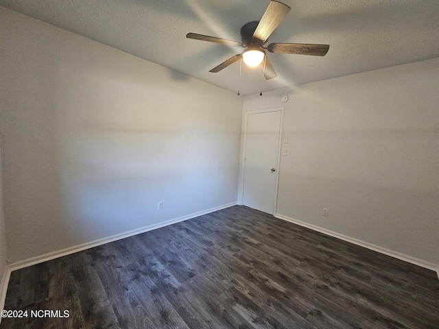 empty room featuring ceiling fan, a textured ceiling, and dark hardwood / wood-style flooring