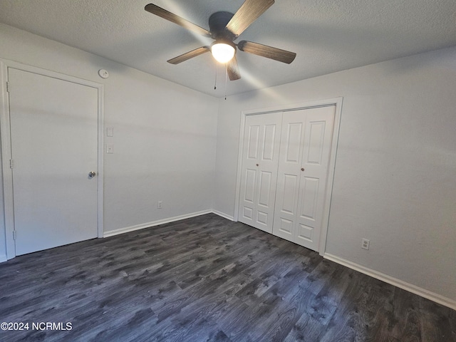 unfurnished bedroom featuring a closet, a textured ceiling, dark wood-type flooring, and ceiling fan