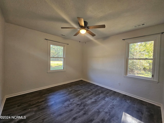 spare room with dark hardwood / wood-style floors, a textured ceiling, and ceiling fan