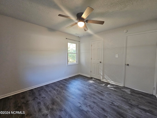 unfurnished bedroom with a textured ceiling, dark hardwood / wood-style floors, and ceiling fan