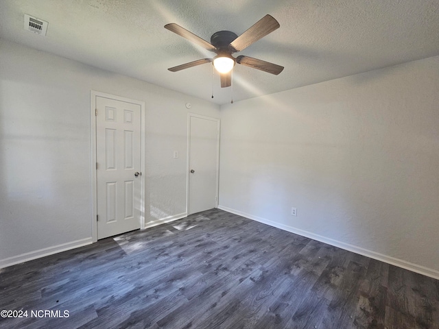 unfurnished bedroom featuring dark wood-type flooring, a textured ceiling, and ceiling fan