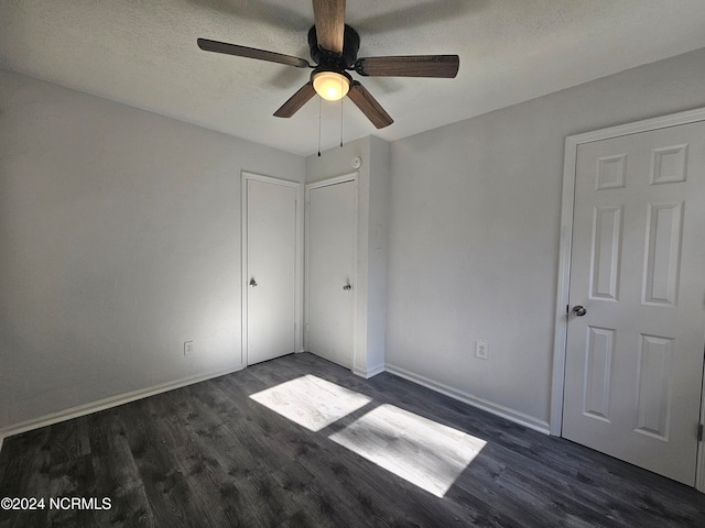 unfurnished bedroom with dark hardwood / wood-style flooring, a textured ceiling, and ceiling fan