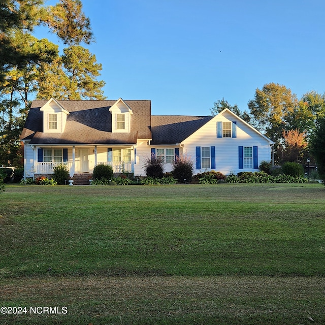 cape cod house with a front yard and covered porch