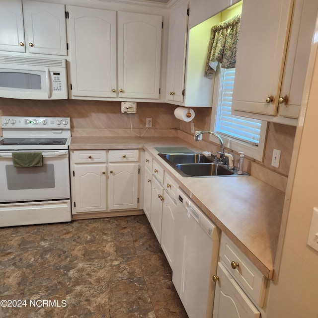 kitchen with white appliances, white cabinetry, and sink