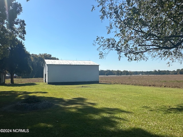 view of yard with an outdoor structure and a rural view