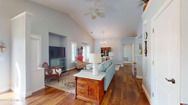 living room featuring lofted ceiling, dark hardwood / wood-style flooring, and ceiling fan with notable chandelier