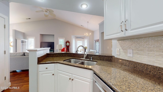 kitchen with lofted ceiling, white cabinets, hardwood / wood-style flooring, dark stone countertops, and sink