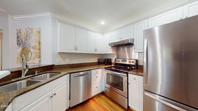 kitchen featuring white cabinetry, appliances with stainless steel finishes, and dark stone counters