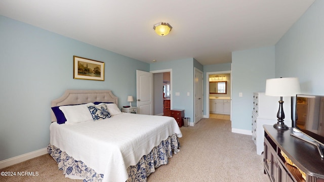 bedroom featuring ensuite bathroom and light colored carpet