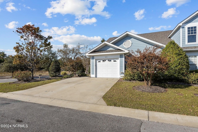 view of front of house with a garage and a front lawn