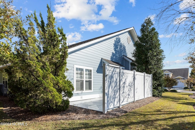 view of side of home with a yard