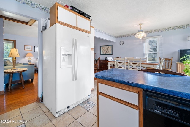 kitchen with light hardwood / wood-style flooring, a textured ceiling, white refrigerator with ice dispenser, and a wealth of natural light